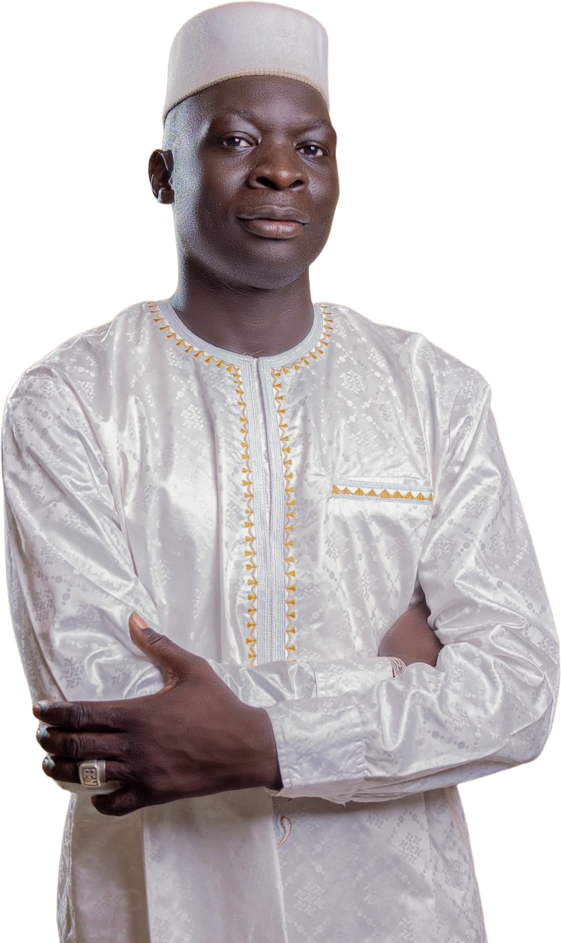 Portrait of Kebba Madi Bojang in a white embroidered kaftan and cap, arms folded